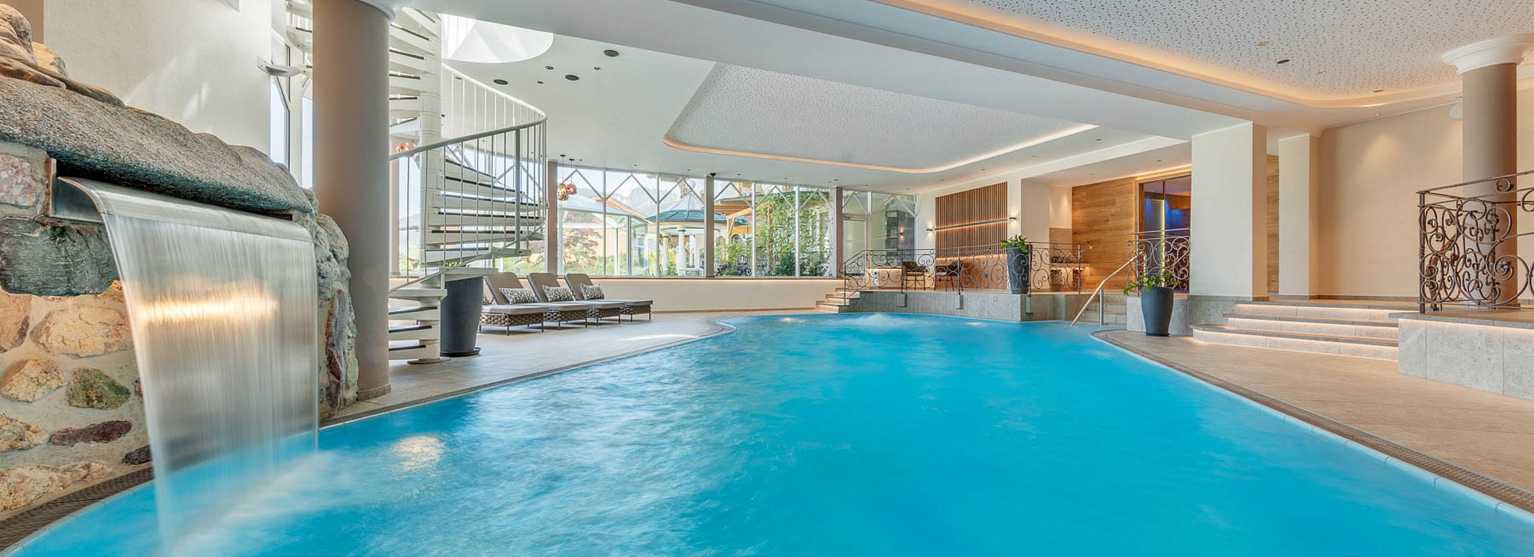 Elevated relaxation area with comfortable wellness loungers and stylish wood design by the pool