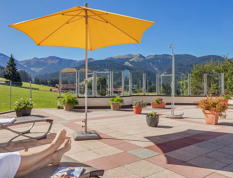 Terrasse mit Sonnenliegen, Garten und Außendusche