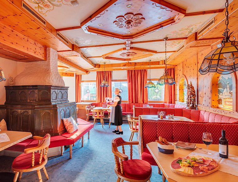 Speisesaal im Tiroler Stil mit Kachelofen und Holztäfelung